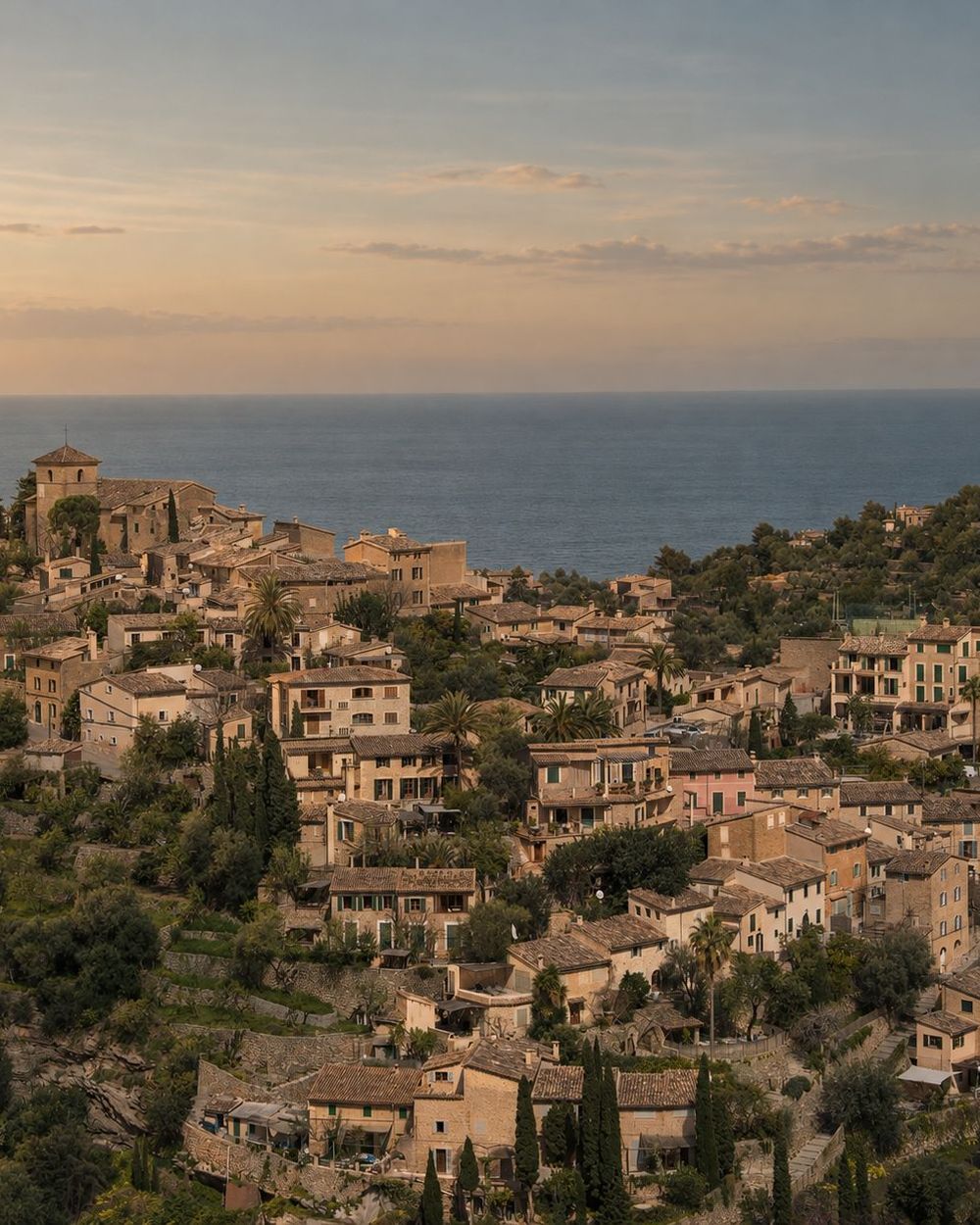 Vista del pueblo de Deià al atardecer, con el mar al fondo