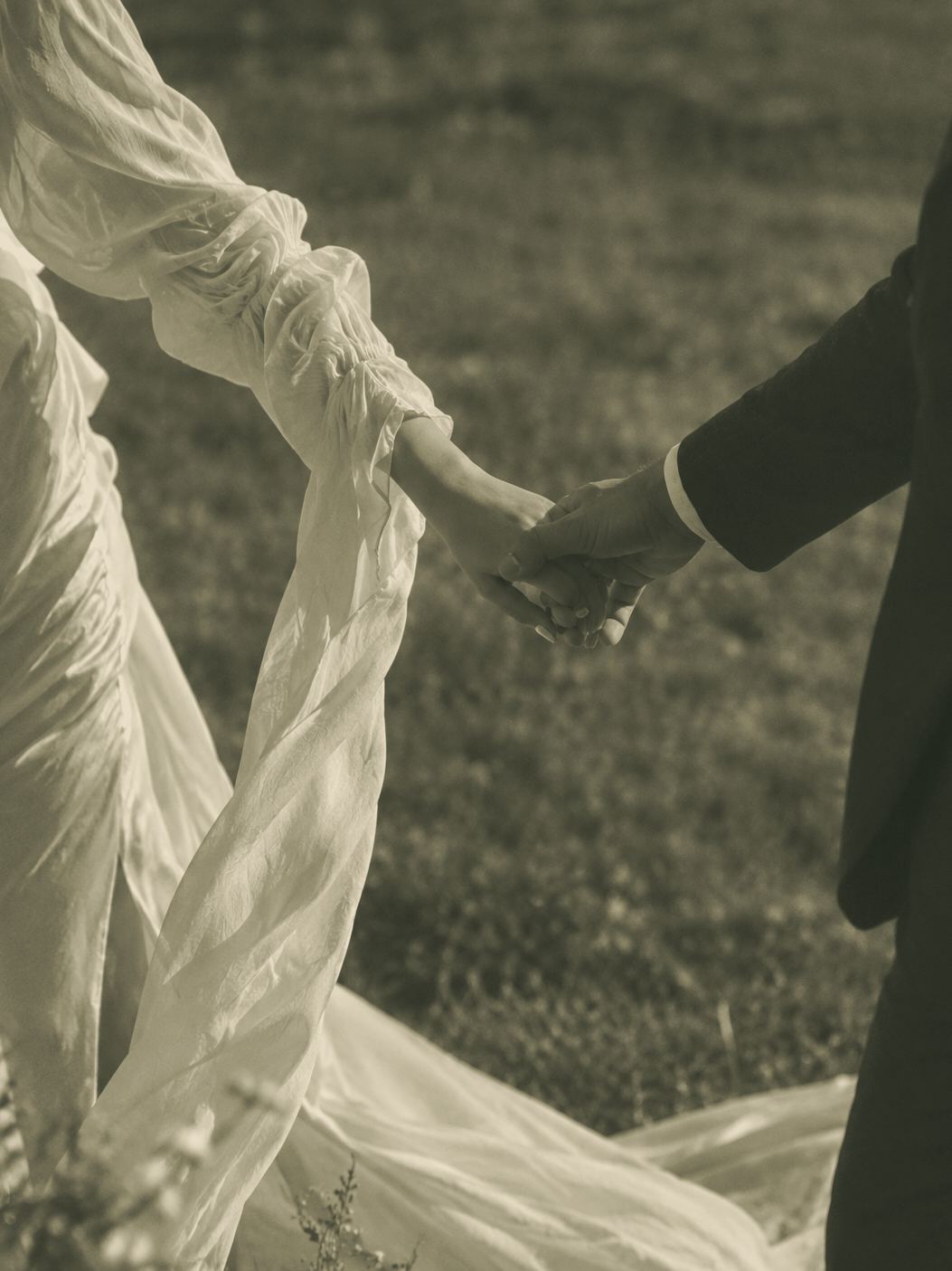 Pareja de novios tomados de la mano al atardecer