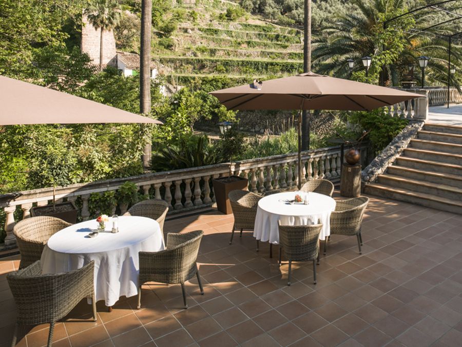 Terraza Deià de Can Quet Deià, con mesas y vistas a la Sierra de Tramuntana