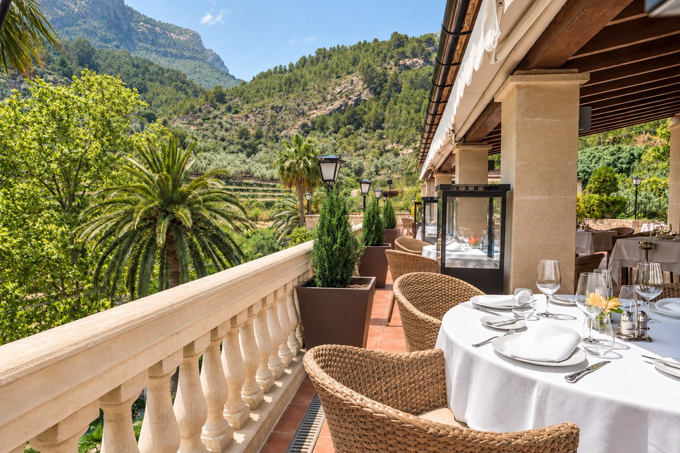 Terraza del restaurante con mesas puestas, balaustrada de piedra y vistas a la Sierra de Tramuntana